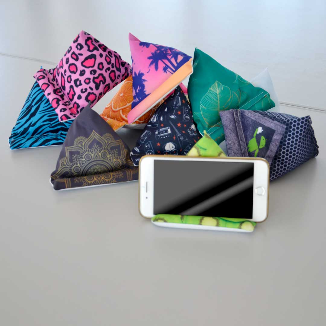 Mehrere bunte Handy-Sitzsäcke mit verschiedenen bedruckten Mustern sind gestapelt, einer davon hält ein Handy.