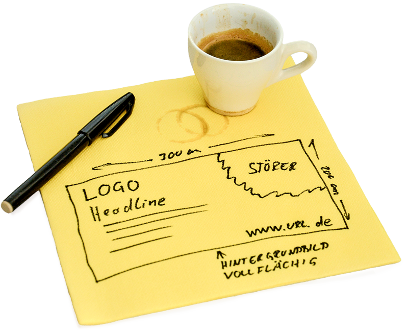 Serviette mit handgezeichneter Layoutskizze, darauf ein Stift und eine Tasse Espresso